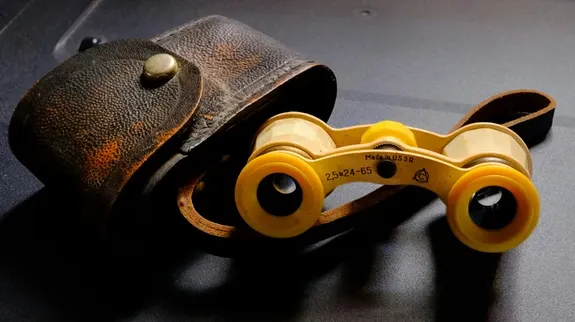 Yellow binoculars with  brown leather case