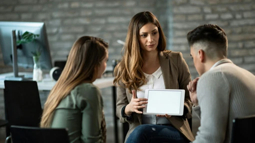 Woman with tablet talking to couple